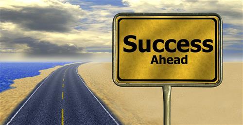 Picture of road sign which reads success ahead next to an empty road 